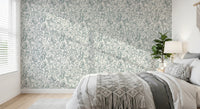 Butterfly Bloom Line Art wallpaper in a bedroom with grey bedding, macrame throw and a leafy plant