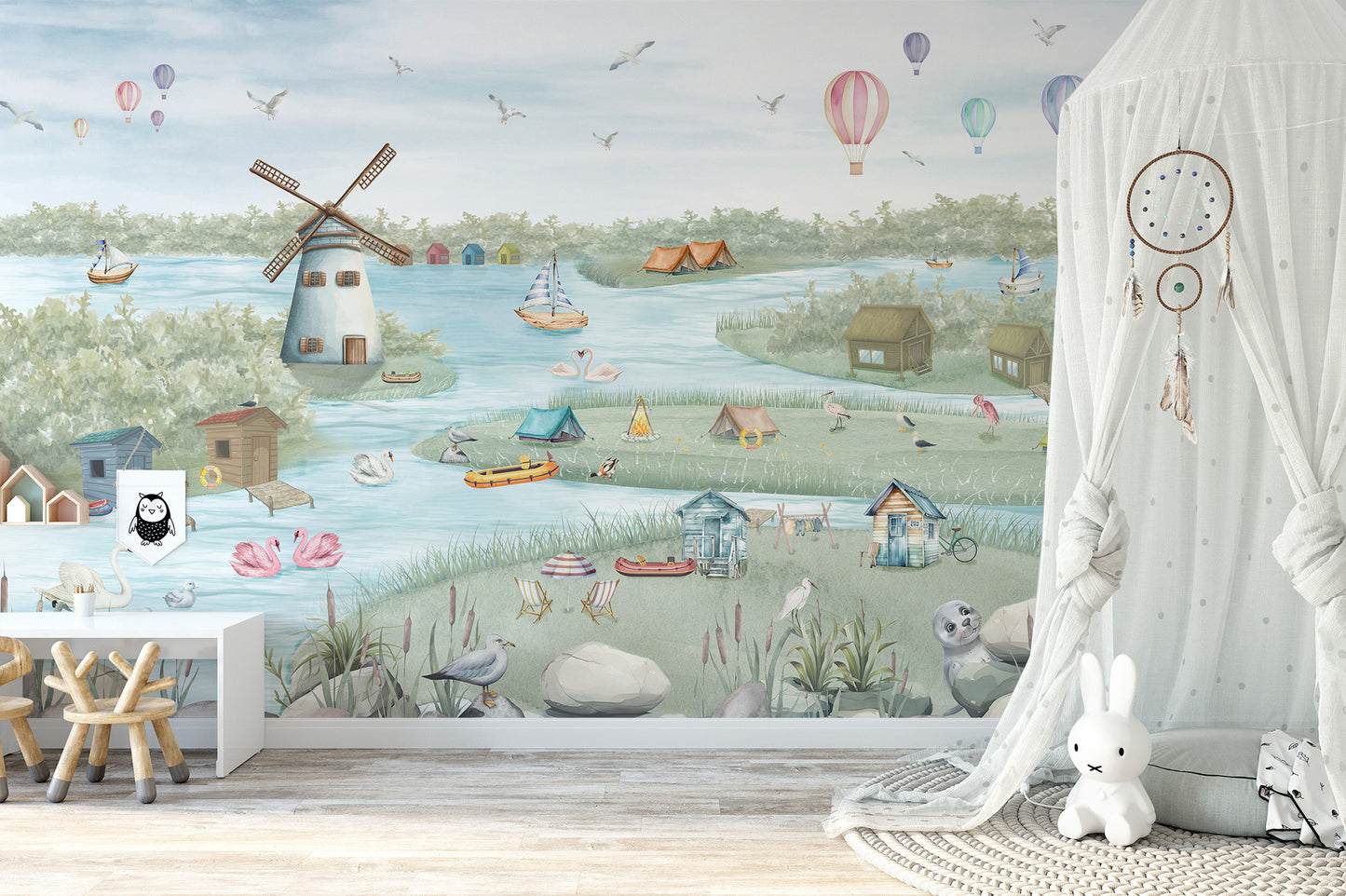 Breezy Shores wallpaper mural of a watercolor lake and windmill in a nursery with a white canopy net and bunny lamp