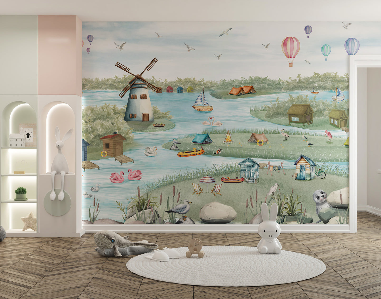 Breezy Shores wallpaper mural of a watercolor lake with a windmill and balloons in a kids room with plush bunnies