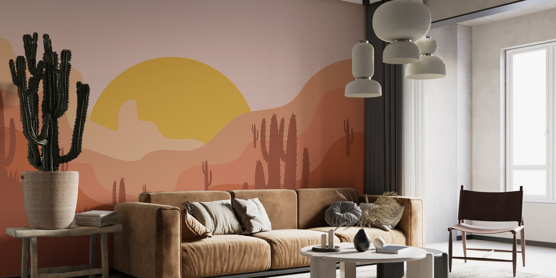 Removable self adhesive desert landscape wall mural in a living room with a brown leather sofa and a large potted cactus.