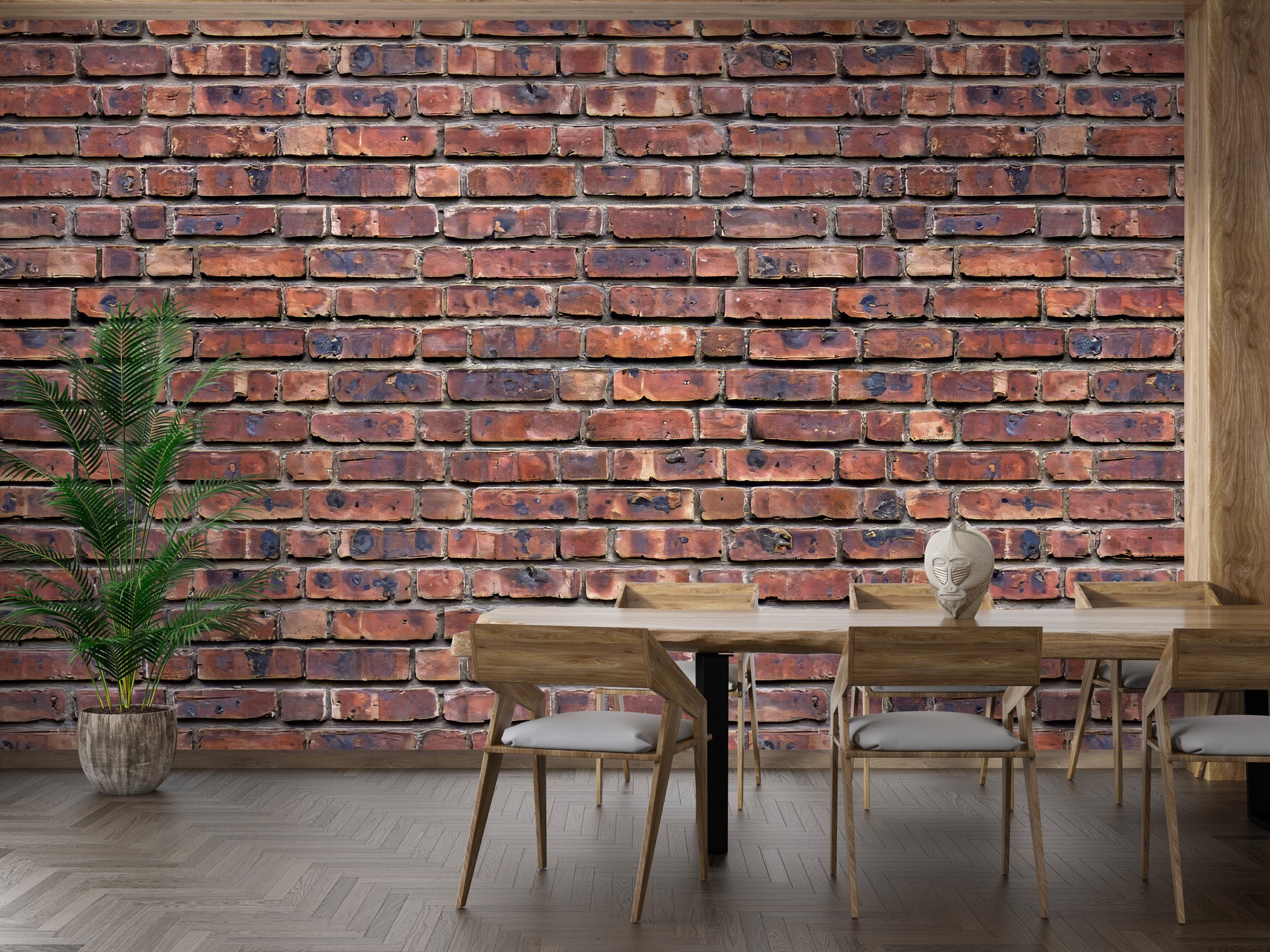Heritage Brickwork wallpaper of weathered red brick behind a wood dining table and chairs with a potted palm