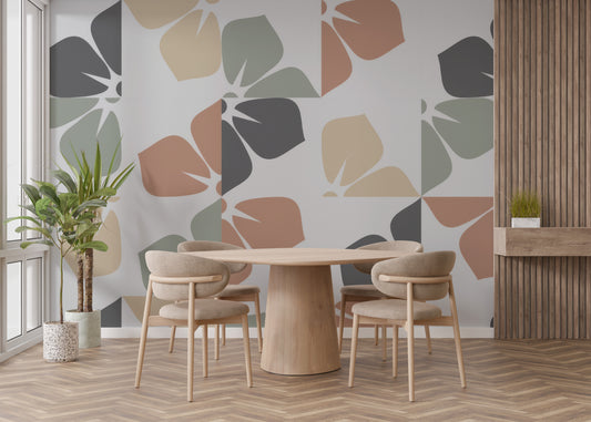 Abstract Foliage wallpaper mural with sage and terracotta leaf shapes in a dining room with round wood table and tan chairs