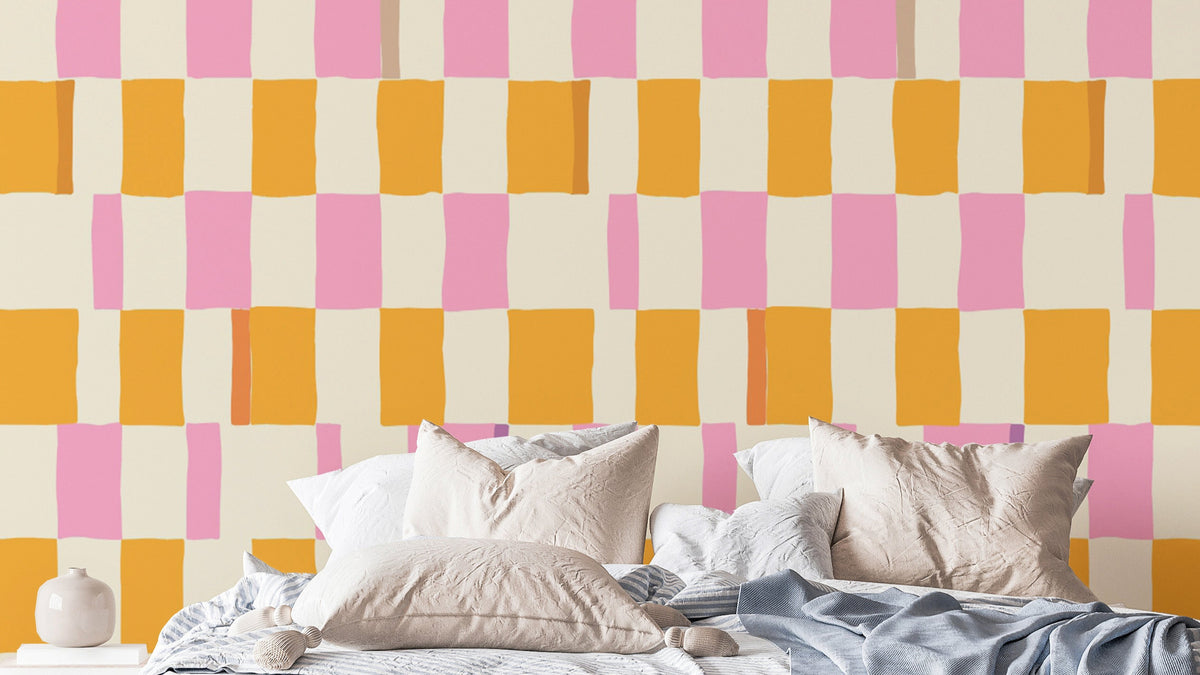 Colorful Checkered wallpaper with hand-painted pink and orange squares above a bed with white pillows