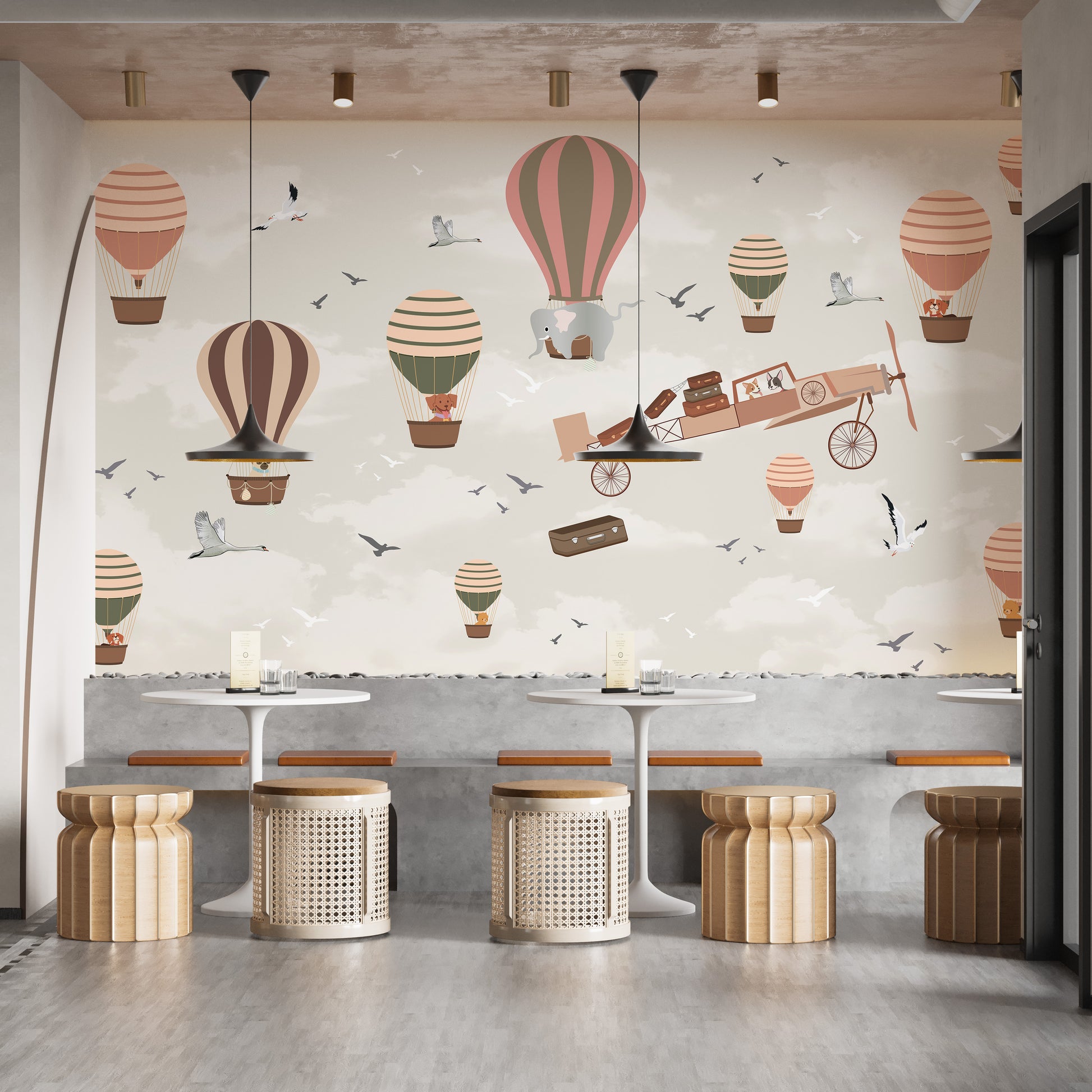 Whimsical Sky High Adventure wallpaper mural of hot air balloons and a plane behind rattan stools and tables in a cafe setting