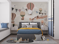 Whimsical Sky High Adventure wallpaper mural of balloons and an airplane above a grey bed with mustard throw in a kids bedroom