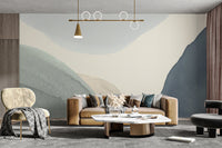 Calming Contours wallpaper mural of layered blue and cream forms behind a tan sofa in a modern living room