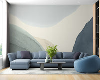 Calming Contours wallpaper mural of abstract blue and beige curves behind a blue sectional in a living room