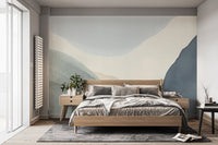 Calming Contours wallpaper mural of soft blue and green wave shapes behind a wood bed in a serene bedroom