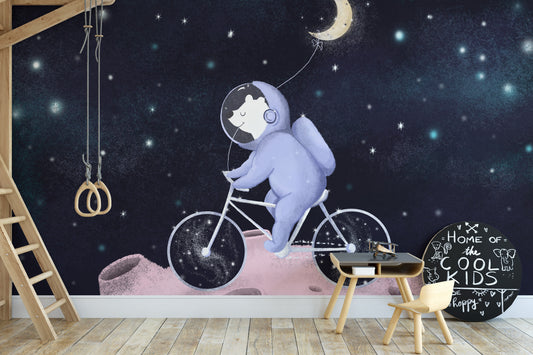 Moonlight Friends wallpaper mural of a purple astronaut bear cycling on a pink moon in a kids room with a loft bed ladder