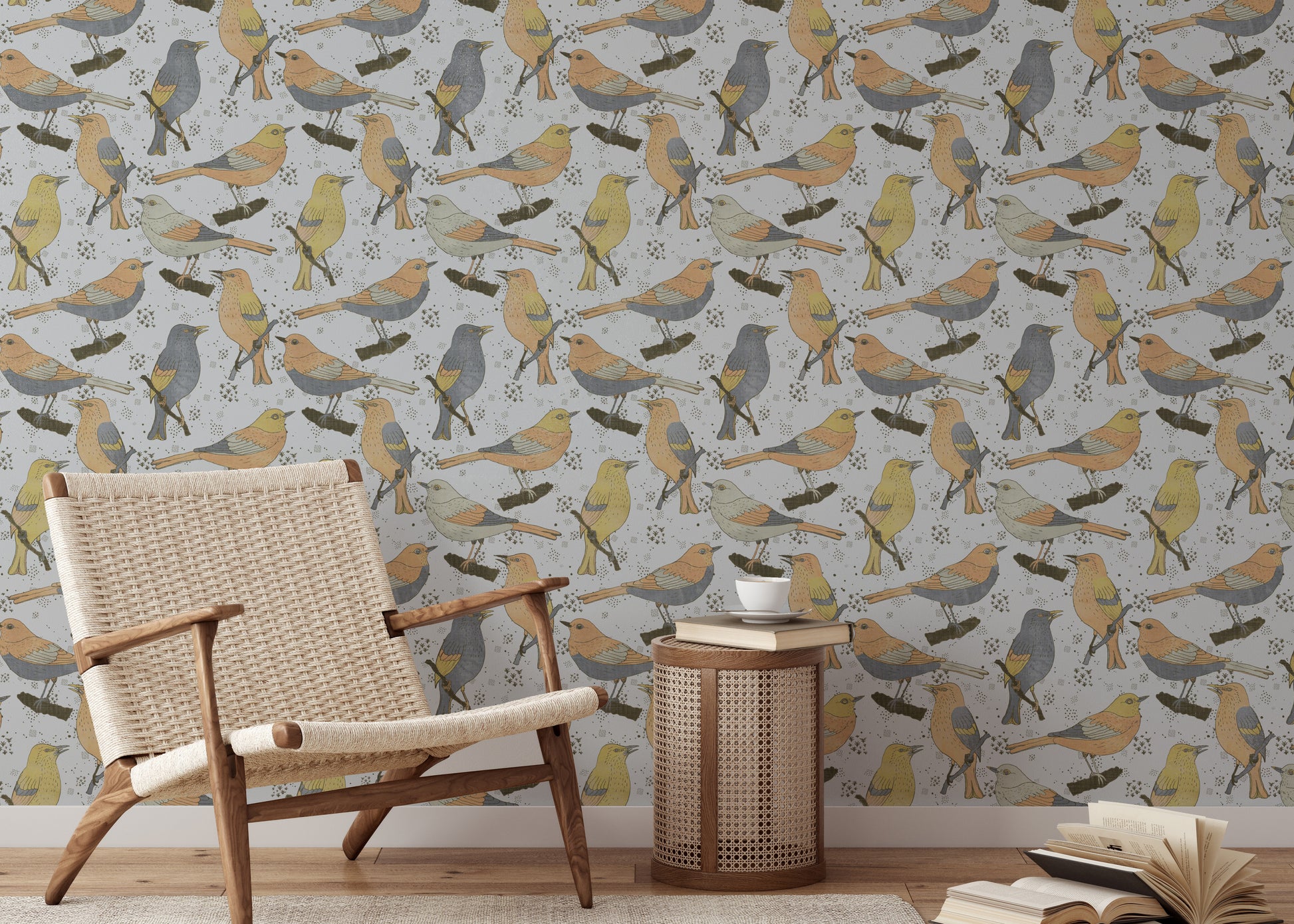 Birds Golden and Gray wallpaper behind a woven cane armchair and cane drum table with a coffee cup