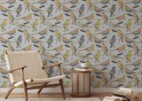 Birds Golden and Gray wallpaper behind a woven cane armchair and cane drum table with a coffee cup