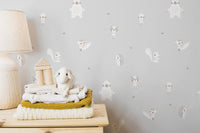 Forest Animals Gray wallpaper close-up behind a wood lamp and folded knit blankets with a lamb plush toy