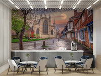Features a historic old town scene with a cobbled street leading towards a grand, Gothic-style cathedral or large church.
