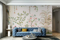 Chinoiserie Garden wallpaper mural with parrots behind a blue tufted sofa with a mustard pillow in a living room