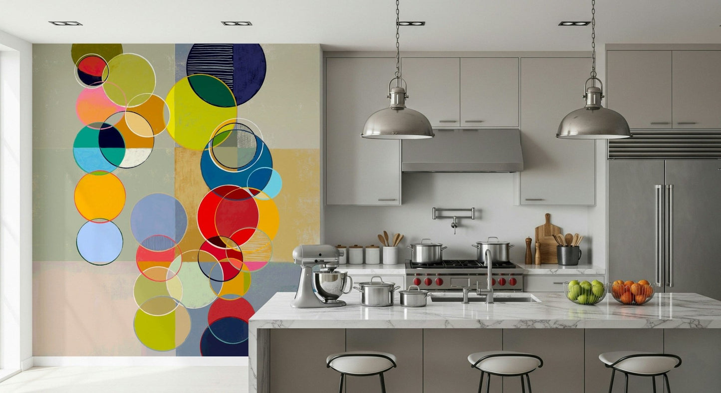 Chromatic Circles wallpaper mural with multicolored circles beside a marble kitchen island and stools
