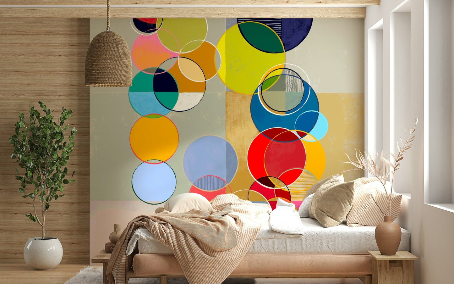 Chromatic Circles wallpaper mural of layered circles above a wood daybed with a striped throw in a bedroom