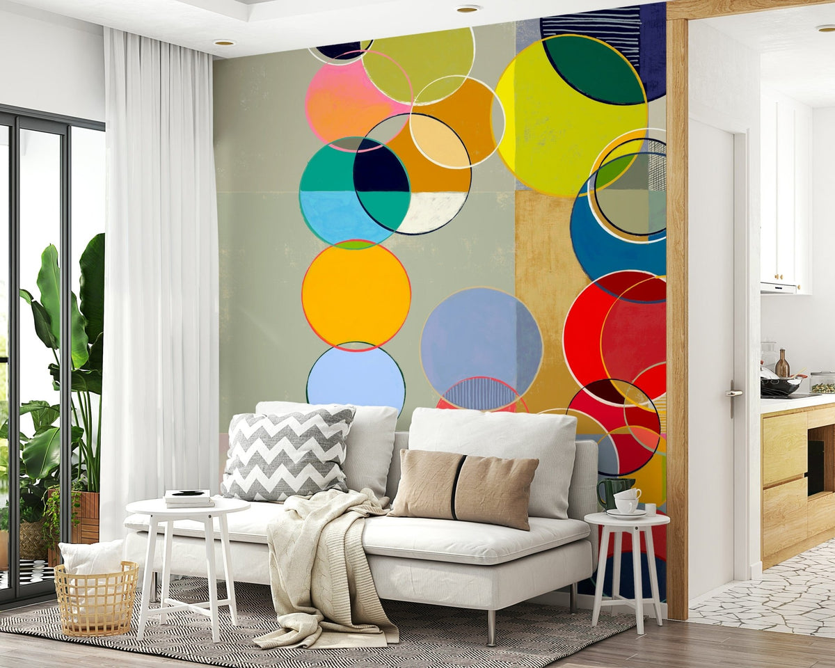 Chromatic Circles wallpaper mural with overlapping circles behind a white sofa with chevron cushions