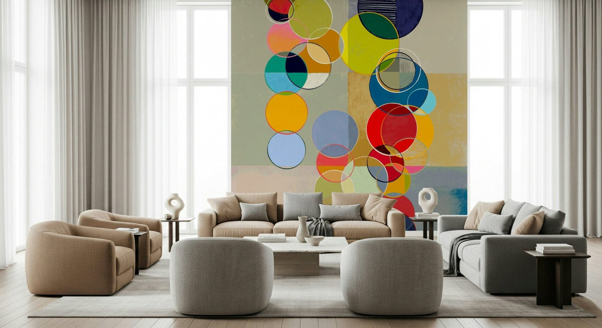 Chromatic Circles wallpaper mural with colorful translucent circles behind beige sofas and round poufs in a living room