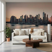 City Lights at Dawn wall mural of the orange-lit skyline behind a white sofa and walnut round table in a living room