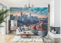 Cityscape Dawn wallpaper mural of a dusk city skyline above a gray sofa and stone fireplace in a living room