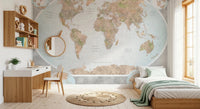 Classic world map in blue and earthy tones wallpaper mural behind a wood desk and bed with a round mirror in a kids room