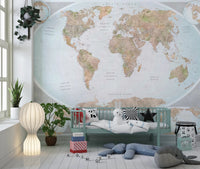 Classic world map in blue and earthy tones wallpaper mural behind a mint daybed with plush toys in a kids room