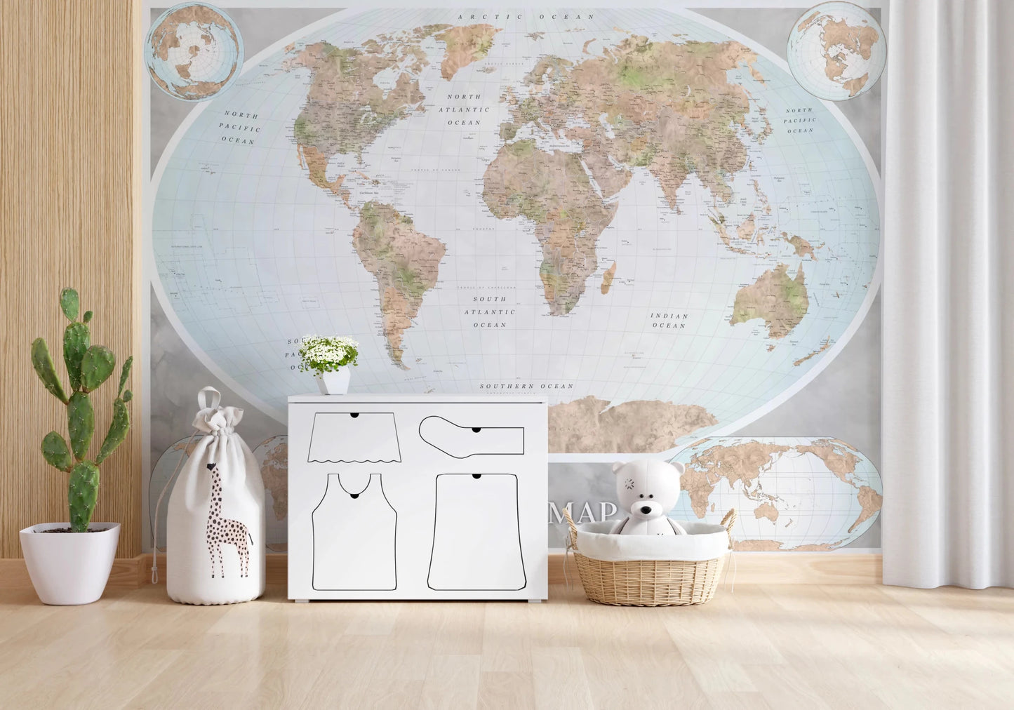 Classic world map in blue and earthy tones wallpaper mural above a white dresser with a teddy basket in a nursery