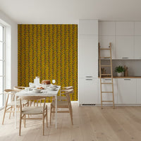 A warm mustard wallpaper decorated with hand-drawn retro leaves rising along slender vines.