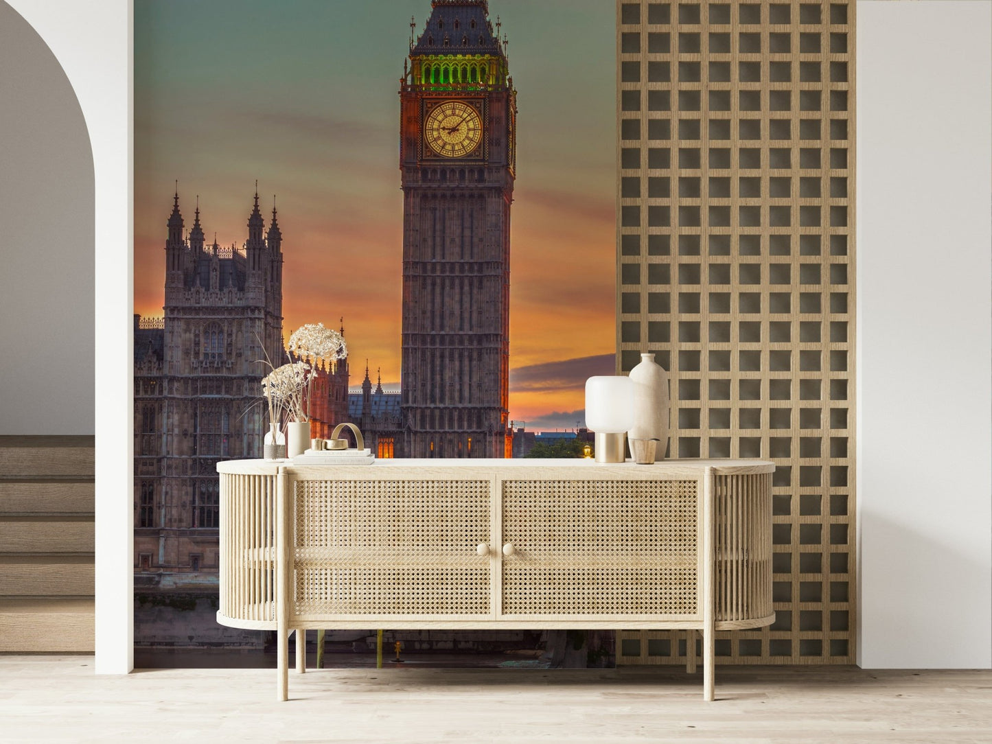 Clock tower wallpaper mural close-up of Big Ben's lit clock above a cane sideboard in an entryway