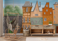 Small Painted City wallpaper mural behind a rattan hammock chair and toy console in a child's room