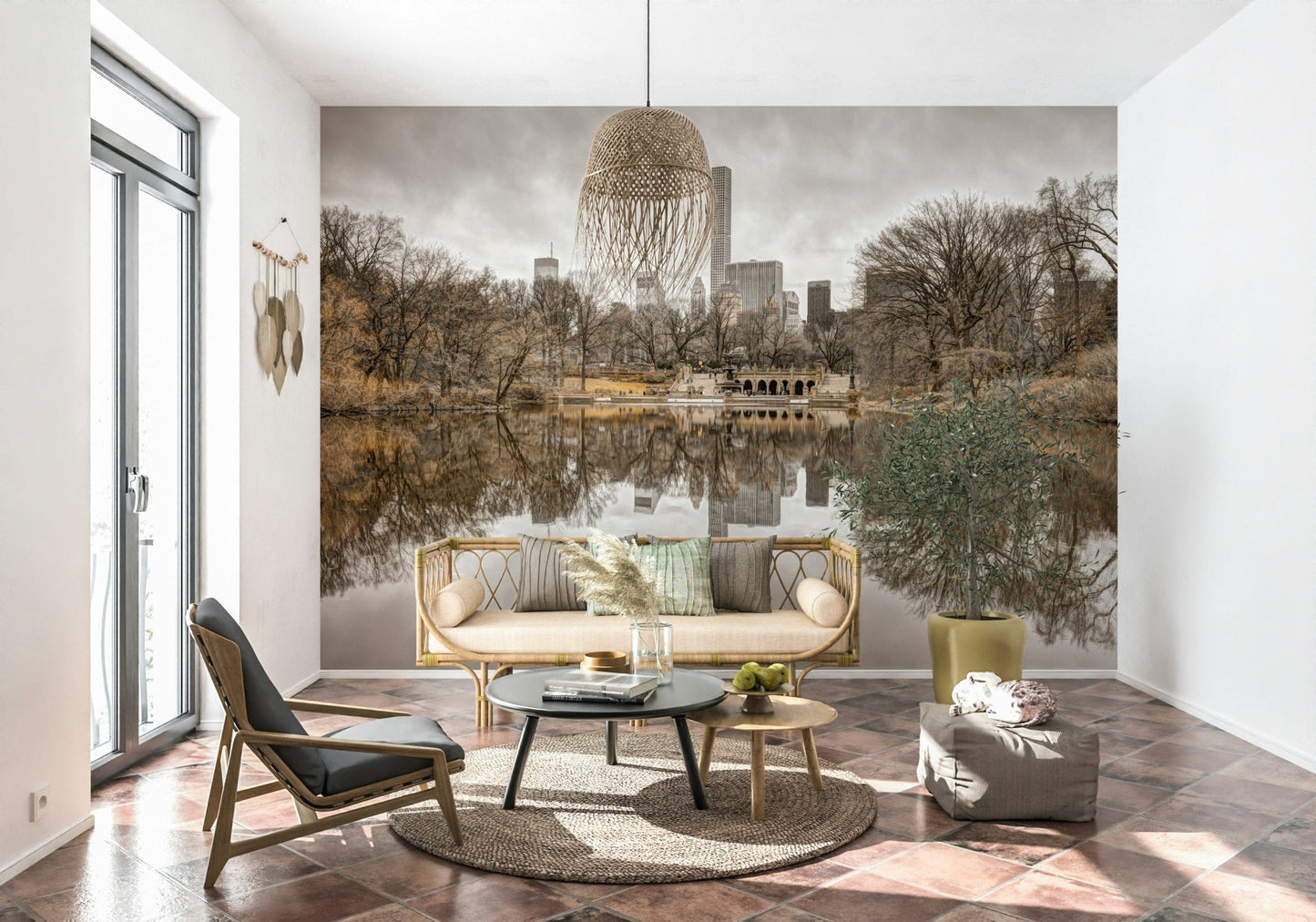 Contrast of Worlds mural above a rattan cane sofa with a round black table and potted olive tree