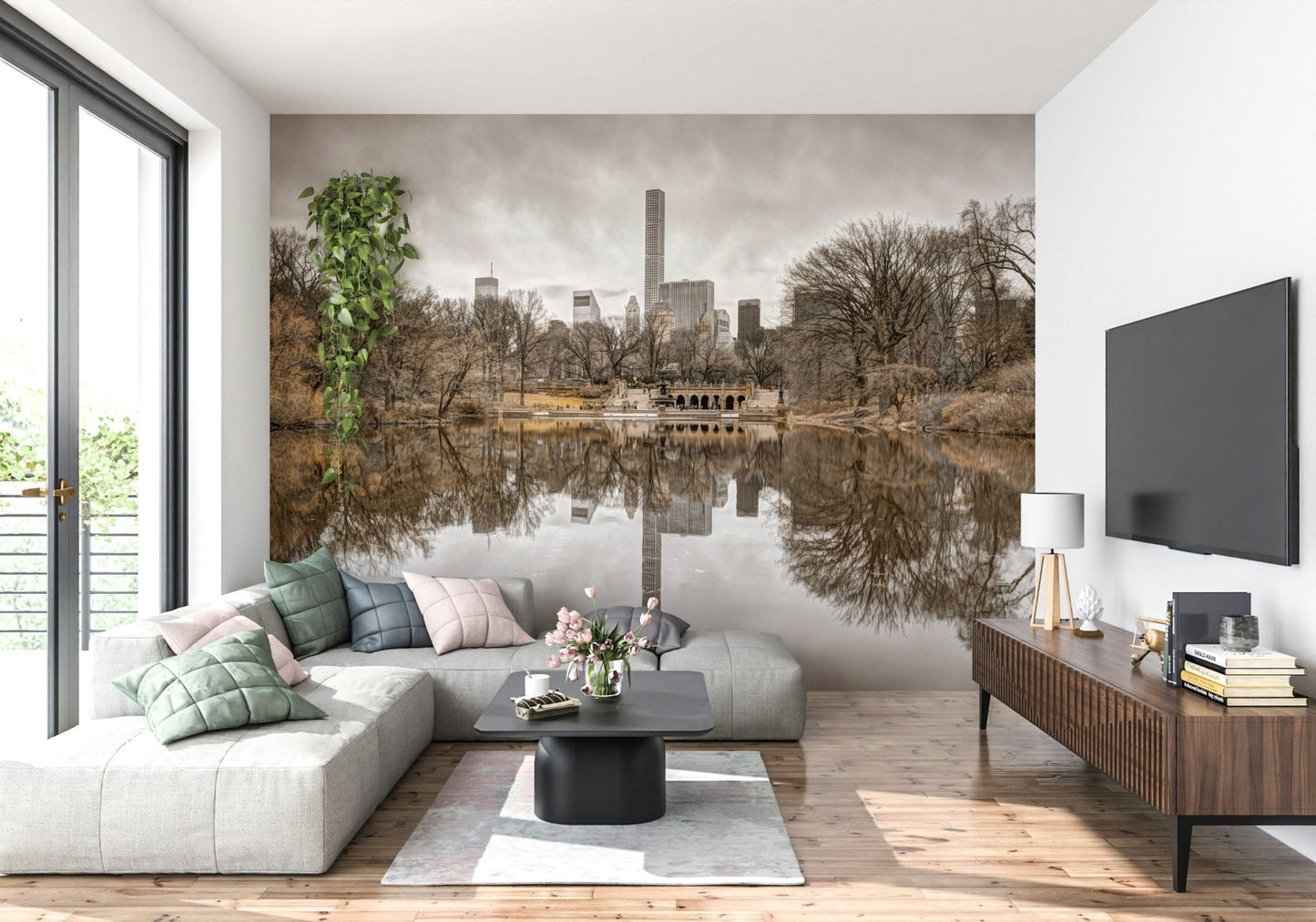 Contrast of Worlds mural above a grey L-shaped sectional with pink and green pillows beside a mounted TV