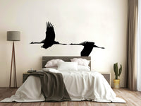 An artistic flying crane mural on minimalist wallpaper.

