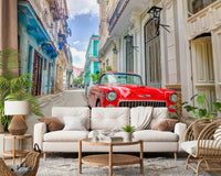 Cuban Classics wallpaper mural of a red vintage car behind a white sofa and rattan chair in a living room