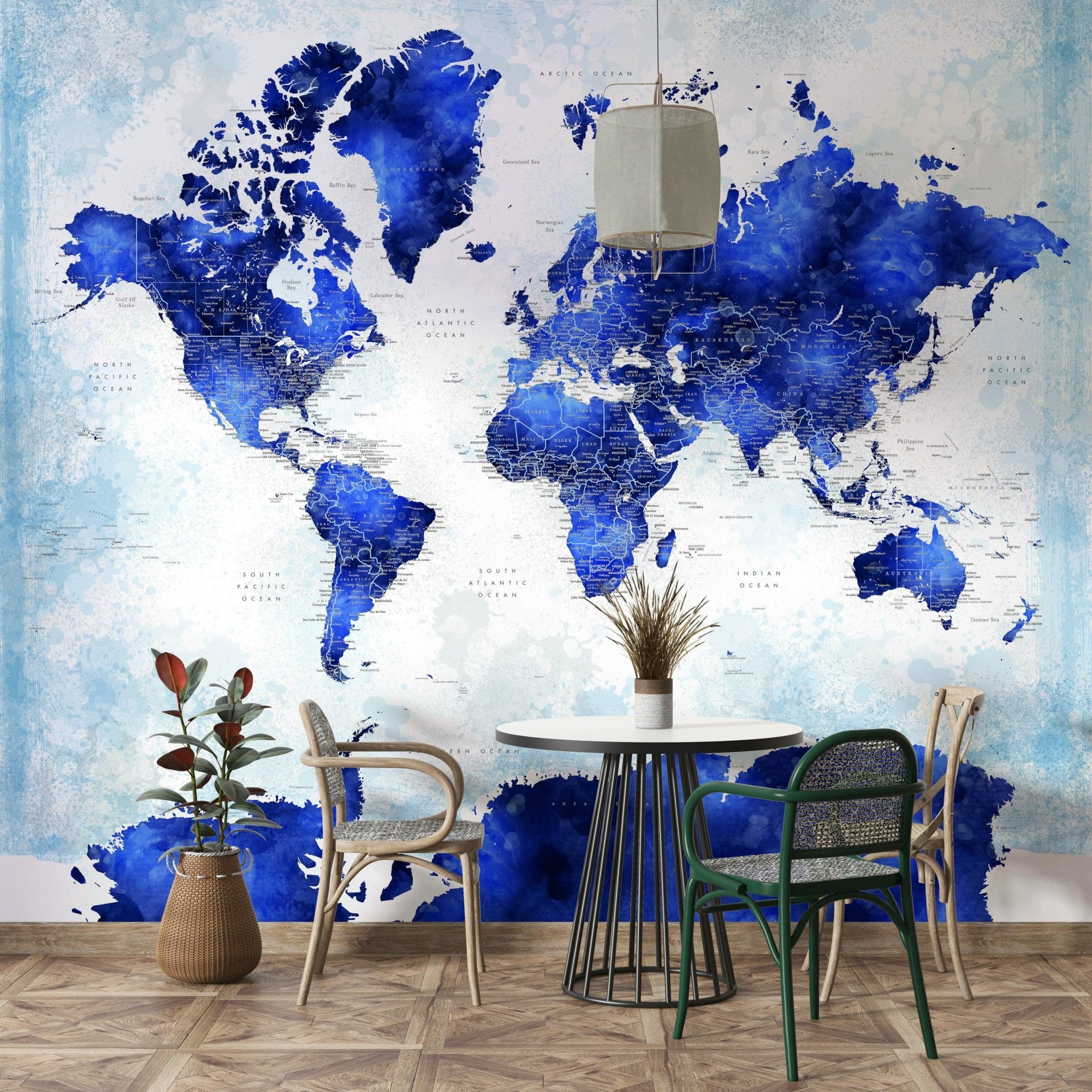 Deep Blue Watercolor World Map wallpaper in a dining nook with a round table, woven chairs and a potted plant