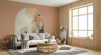 Delicate Bloom Frame wallpaper mural in soft blush and teal behind a white sofa with a rattan coffee table in a living room