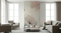 Delicate Floralscape wallpaper mural on an accent wall behind a beige sofa and armchairs in a bright lounge