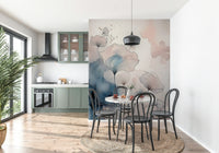 Delicate Floralscape wallpaper mural behind a terrazzo dining table and black bentwood chairs by sage cabinets