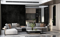 Dirty Paper - Cave wallpaper mural of a moody dark wall behind grey sectional sofas in a luxe living room
