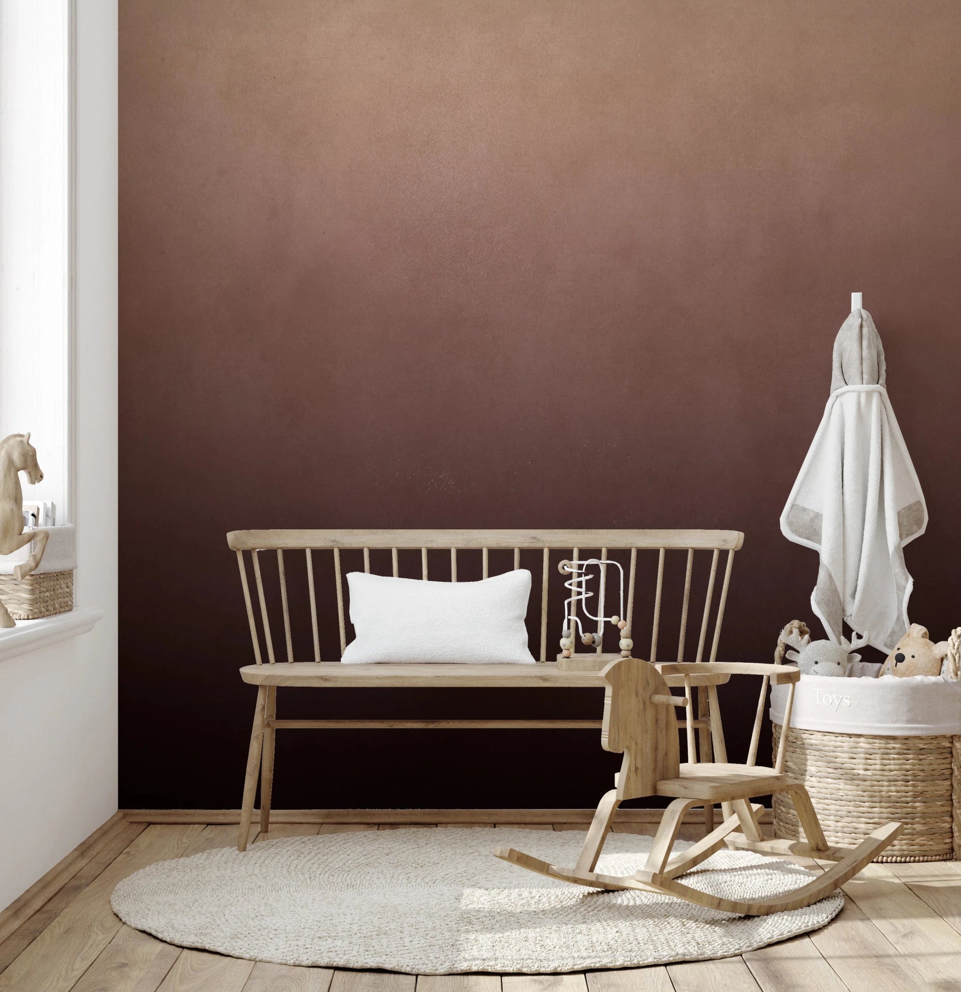 Dirty Paper Ombre Peach wall mural in a nursery with wooden bench, rocking horse and toy basket on a round rug