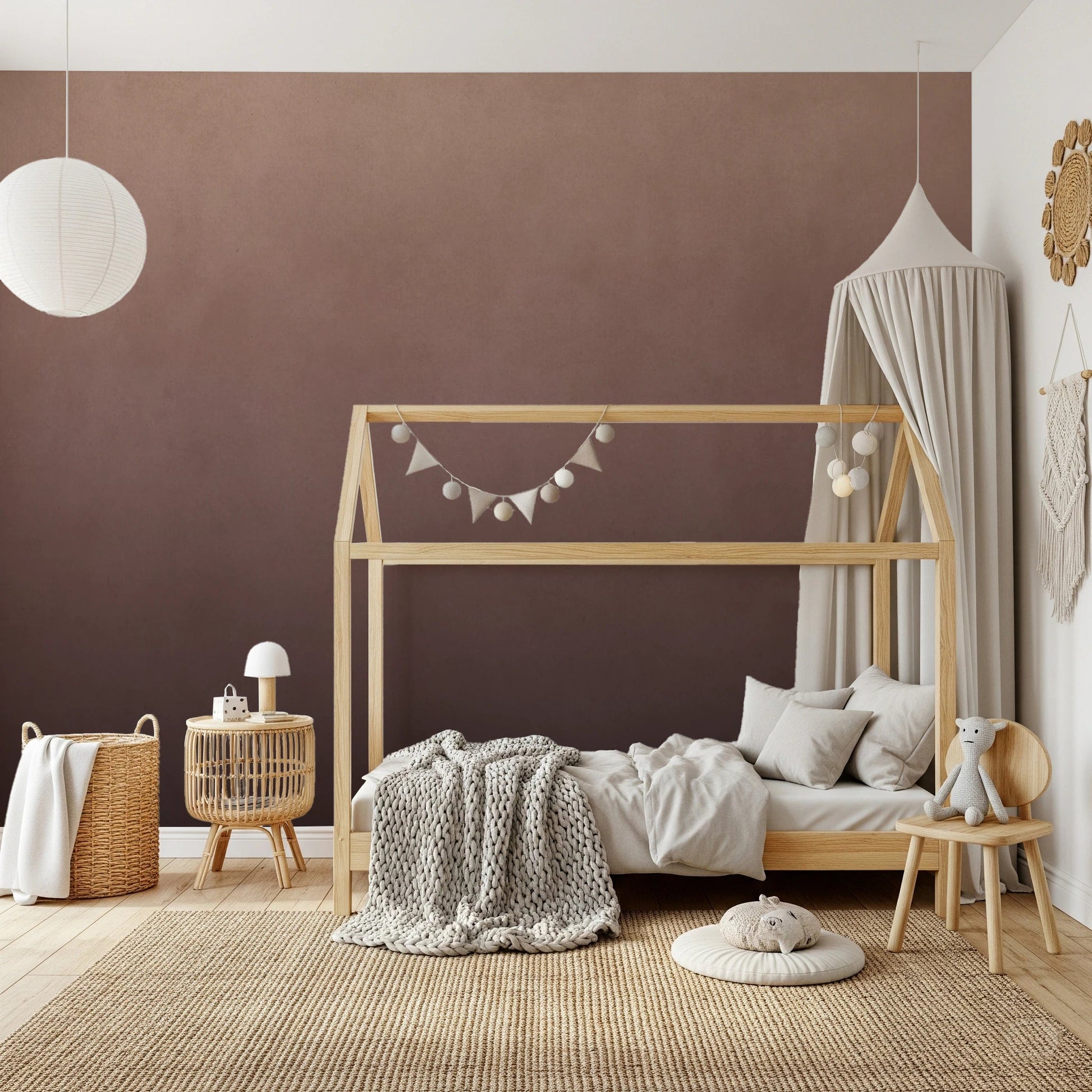 Dirty Paper Ombre Peach wall mural in a kids room with wooden house bed, canopy and knitted throw on a jute rug