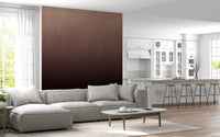 Dirty Paper Ombre Peach wall mural beside a white kitchen with bar stools and a grey sectional in the living room