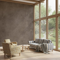 Dirty Paper Taupe wall mural in a sunroom with blue-striped sofa and patterned armchair by tall garden windows