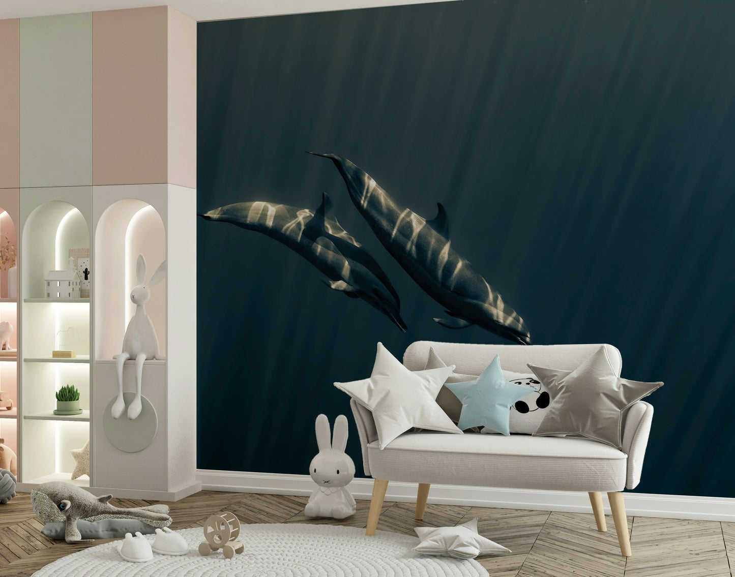 Deep Blue Journey wallpaper mural of two dolphins in deep teal ocean behind a cream settee with star pillows in a nursery