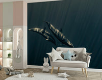 Deep Blue Journey wallpaper mural of two dolphins in deep teal ocean behind a cream settee with star pillows in a nursery