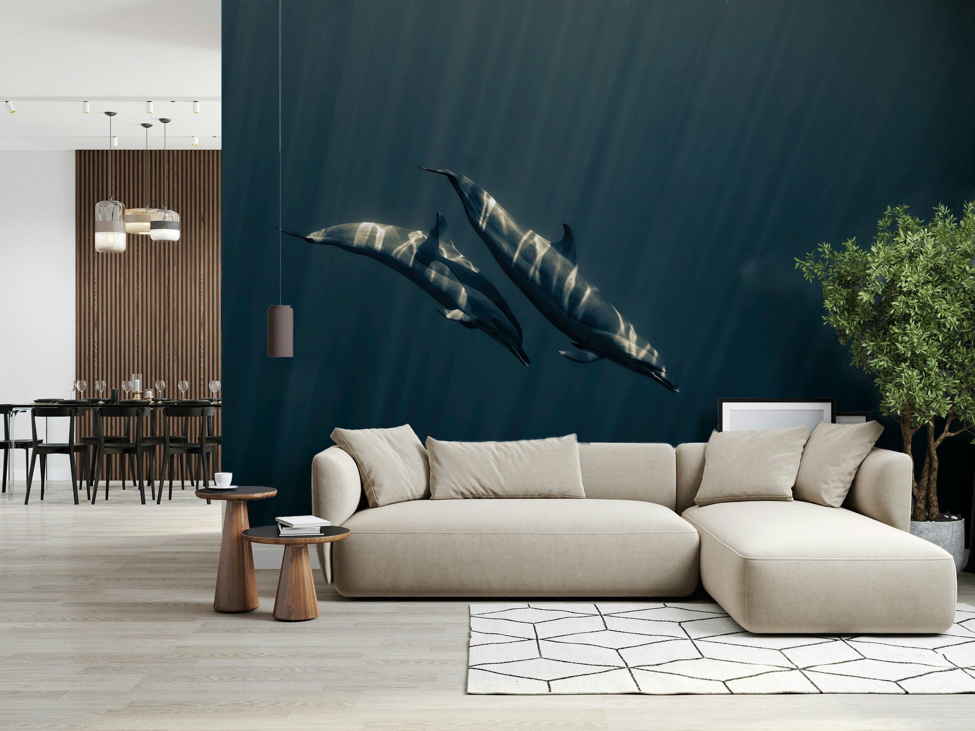 Deep Blue Journey wallpaper mural of two dolphins in sunlit teal water behind a large beige sectional sofa in an open living room