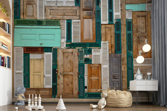 Doorscape Collage wallpaper mural of reclaimed teal and wood doors in a nursery with toys, bean bag and bookshelf