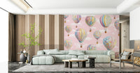 Dreamy Balloon Voyage wallpaper mural with pastel hot air balloons behind a mint sectional sofa and wood-slat wall