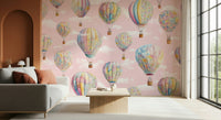 Dreamy Balloon Voyage wallpaper mural of pastel floral balloons on pink sky in a living room with grey sofa