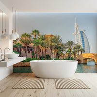 Dubai Oasis wallpaper mural of the Burj Al Arab and palms behind a white freestanding tub in a bathroom